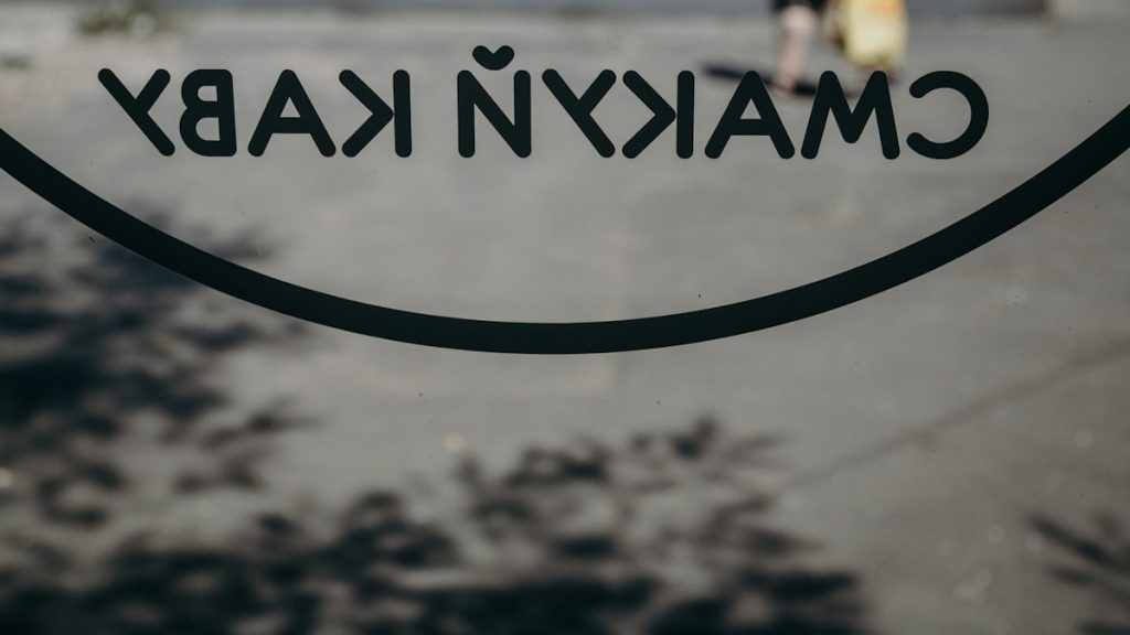 a close up of a sign with a person walking in the background