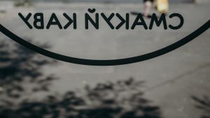 a close up of a sign with a person walking in the background