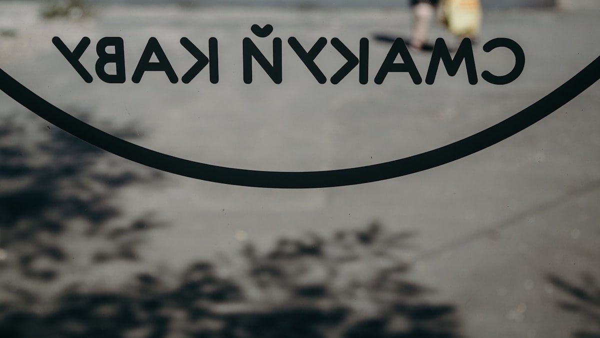 a close up of a sign with a person walking in the background